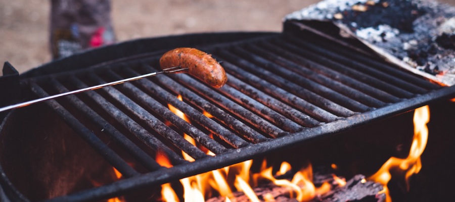 Worstje op een spies boven een bbq.