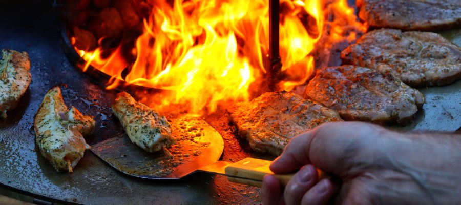 Vleesspiesjes en koteletjes op een plancha bbq.